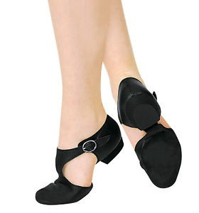 A pair of black dance shoes with buckles, worn on model's feet, viewed from the side.
